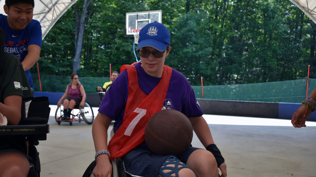Sports Camp - A boy in a wheelchair enjoys basketball